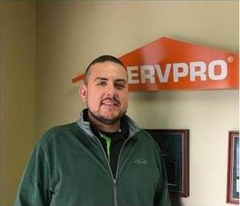 Employee Standing in front of a SERVPRO sign